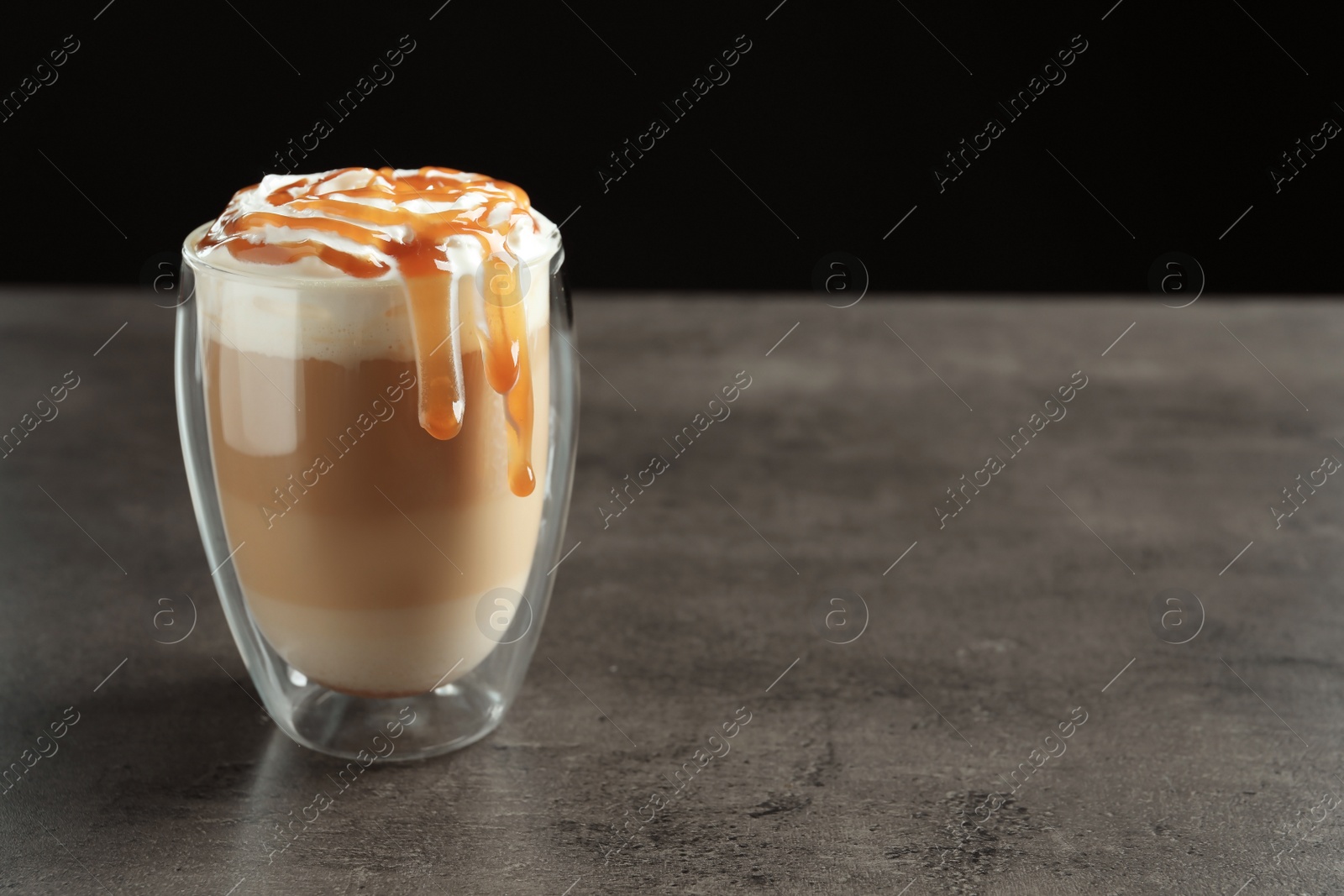 Photo of Glass with delicious caramel frappe on table