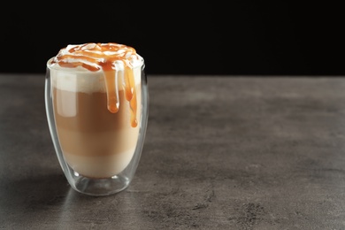 Photo of Glass with delicious caramel frappe on table