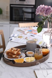 Tray with tasty breakfast on white table