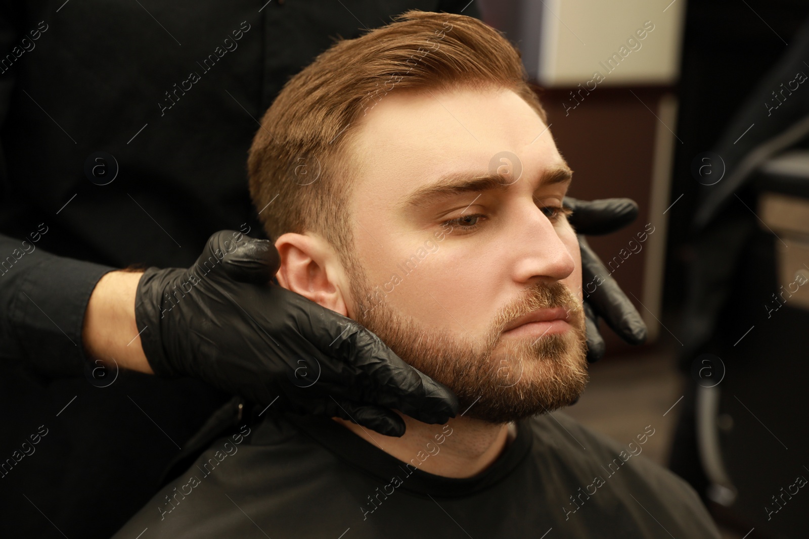 Photo of Professional hairdresser working with client in barbershop