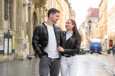 Lovely young couple walking together on city street. Romantic date