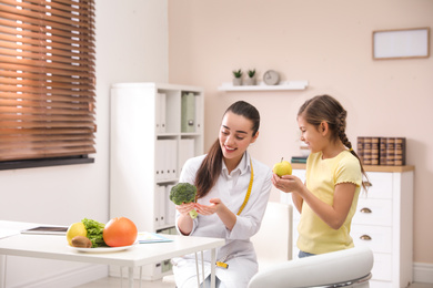 Photo of Little girl visiting professional nutritionist in office