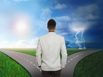 Image of Man at crossroads choosing between sunny and stormy ways