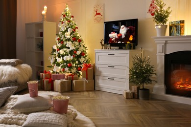 Image of Stylish living room interior with TV set, Christmas tree and fireplace