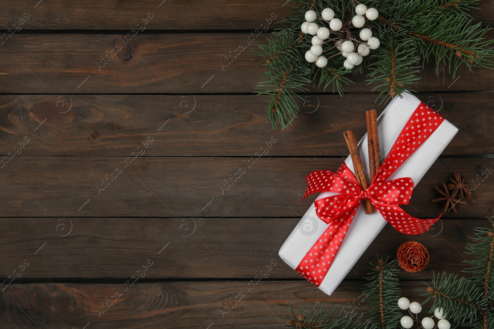 Photo of Flat lay composition with white Christmas gift box on wooden table. Space for text