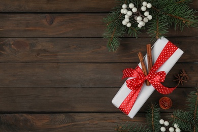 Photo of Flat lay composition with white Christmas gift box on wooden table. Space for text