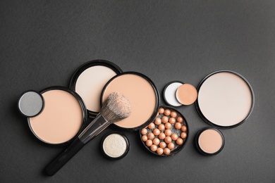 Photo of Flat lay composition with various makeup face powders on black background. Space for text