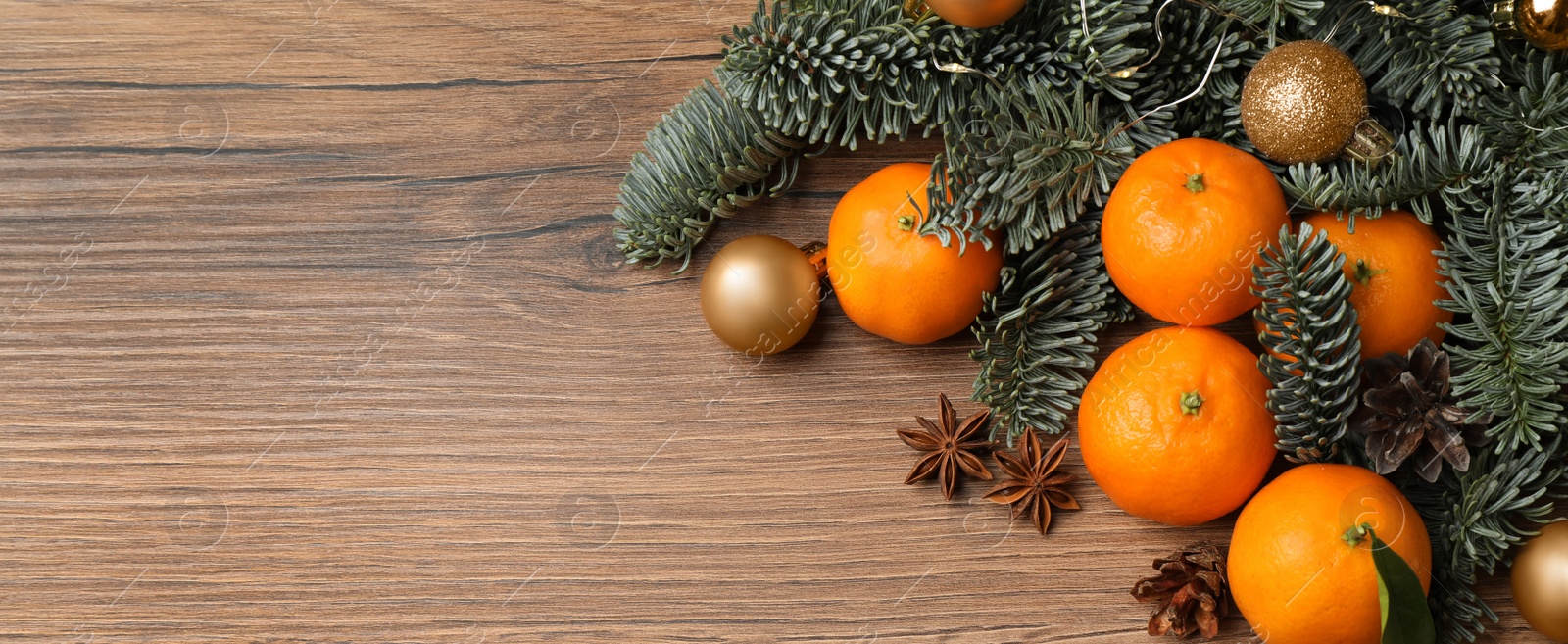 Image of Christmas composition with tangerines on wooden table, flat lay with space for text. Banner design