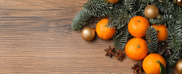 Image of Christmas composition with tangerines on wooden table, flat lay with space for text. Banner design