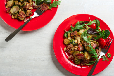 Photo of Salad with roasted brussels sprouts and bacon on white wooden table, flat lay