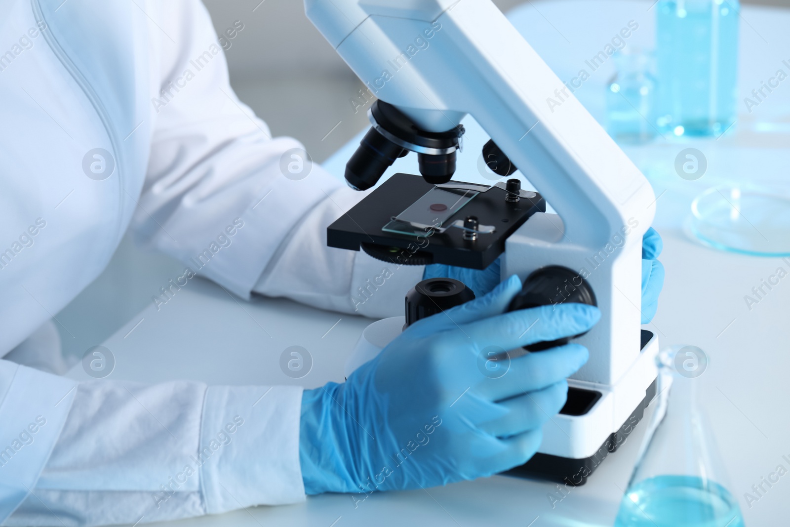 Photo of Scientist working with microscope at table, closeup. Medical research