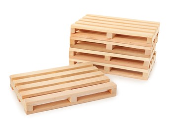 Photo of Many small wooden pallets on white background