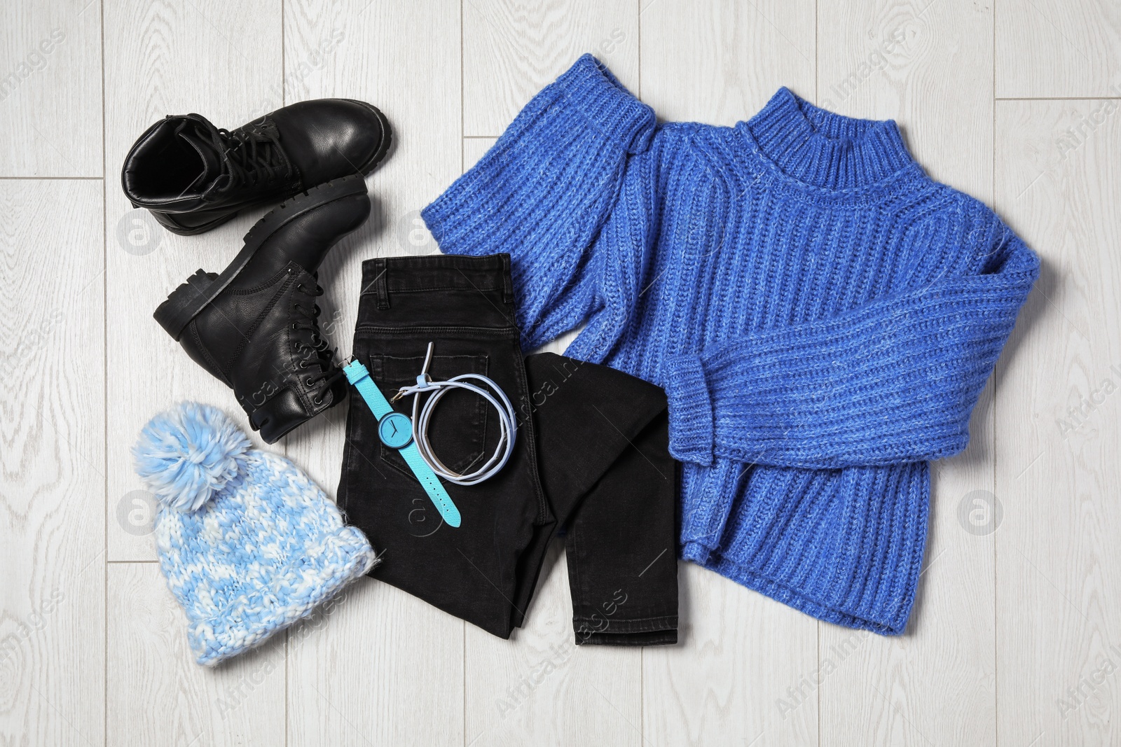 Photo of Flat lay composition with winter clothes and boots on white wooden background