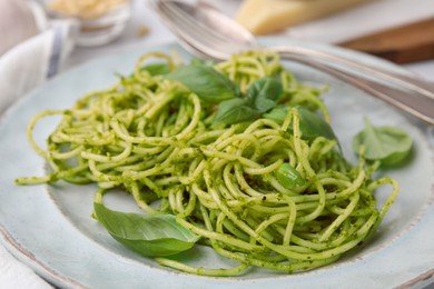 Photo of Delicious pasta with pesto sauce and basil on plate, closeup