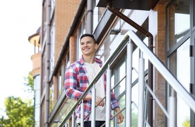 Photo of Young man in stylish outfit outdoors. T-shirt as mockup for design