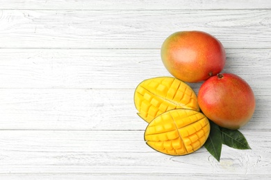 Photo of Flat lay composition with mango on white wooden background. Space for text