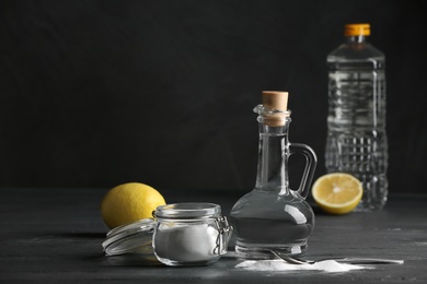 Photo of Composition with vinegar, lemon and baking soda on table