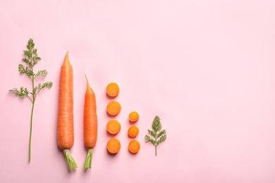 Flat lay composition with fresh carrots on color background