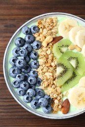 Tasty smoothie bowl with fresh fruits and oatmeal on wooden table, top view