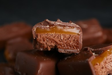 Delicious chocolate candy bars with caramel on dark background, closeup