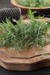 Photo of Fresh dill on wooden board, closeup view