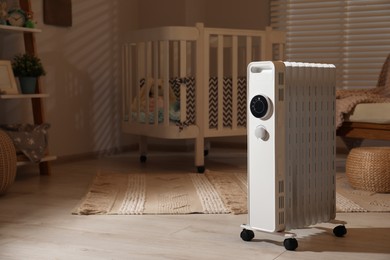 Modern portable electric heater in child room, space for text