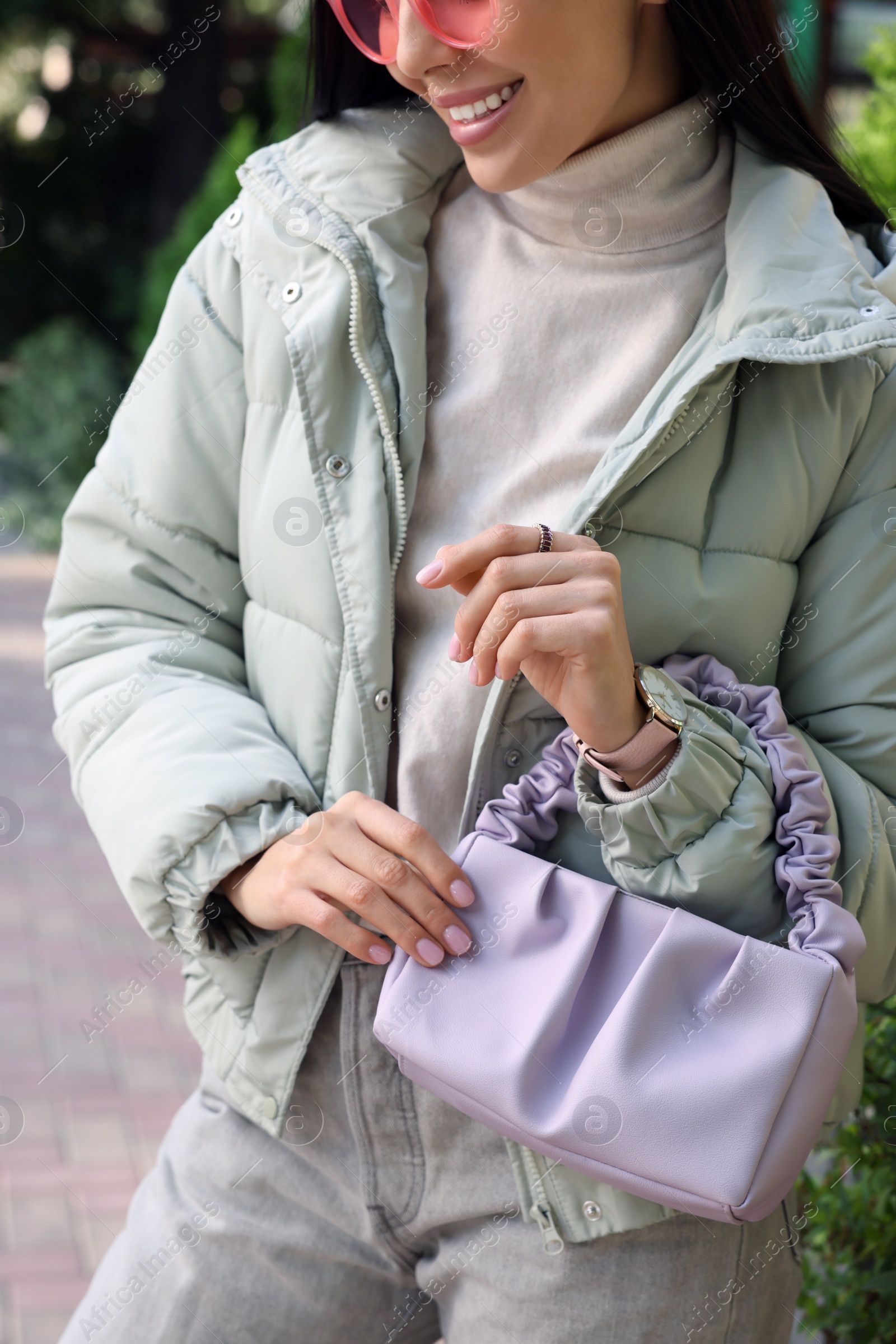 Photo of Fashionable young woman with stylish bag on city street, closeup