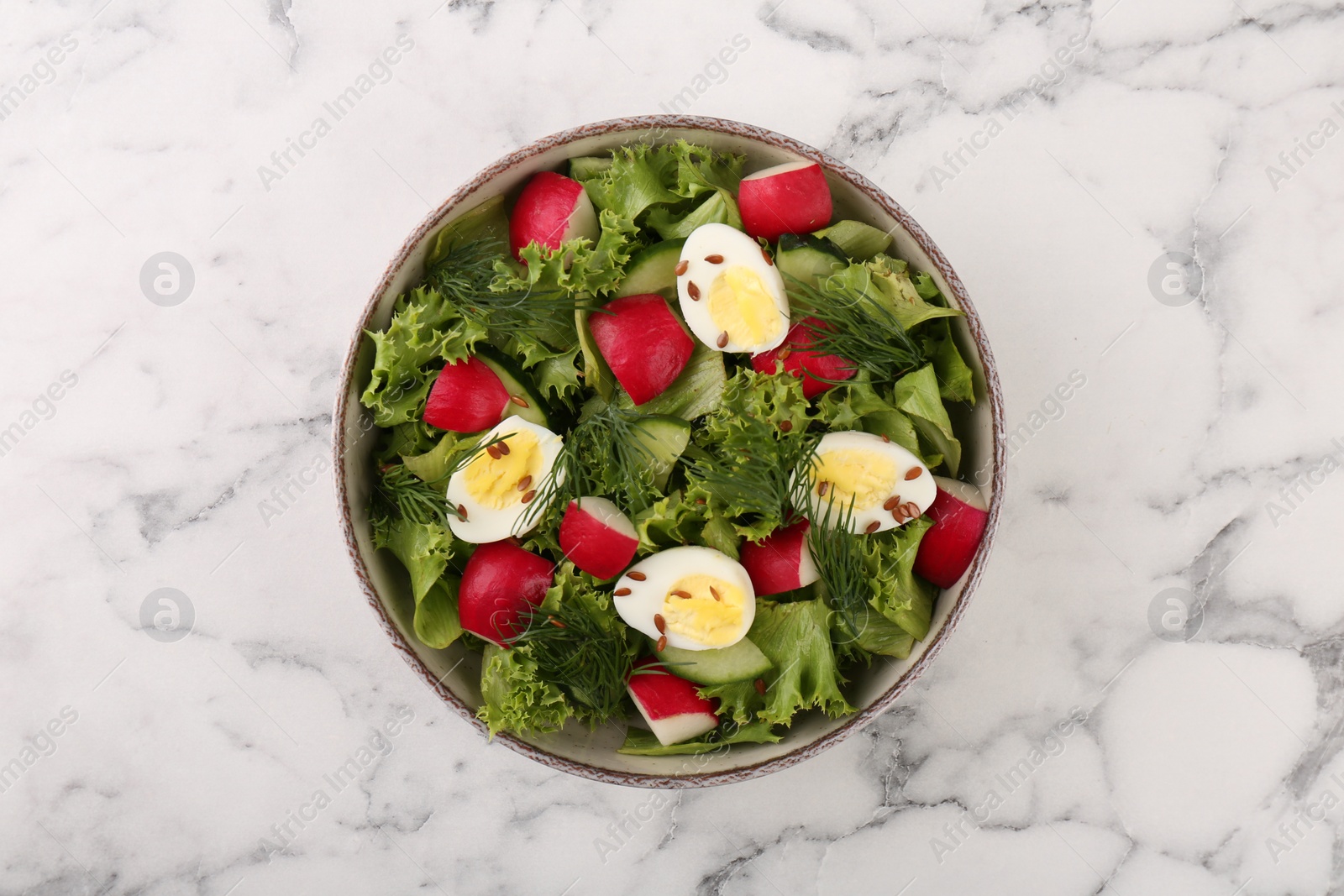 Photo of Delicious salad with radish, lettuce and boiled quail eggs on white marble table, top view