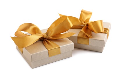 Photo of Golden gift boxes with satin bows on white background
