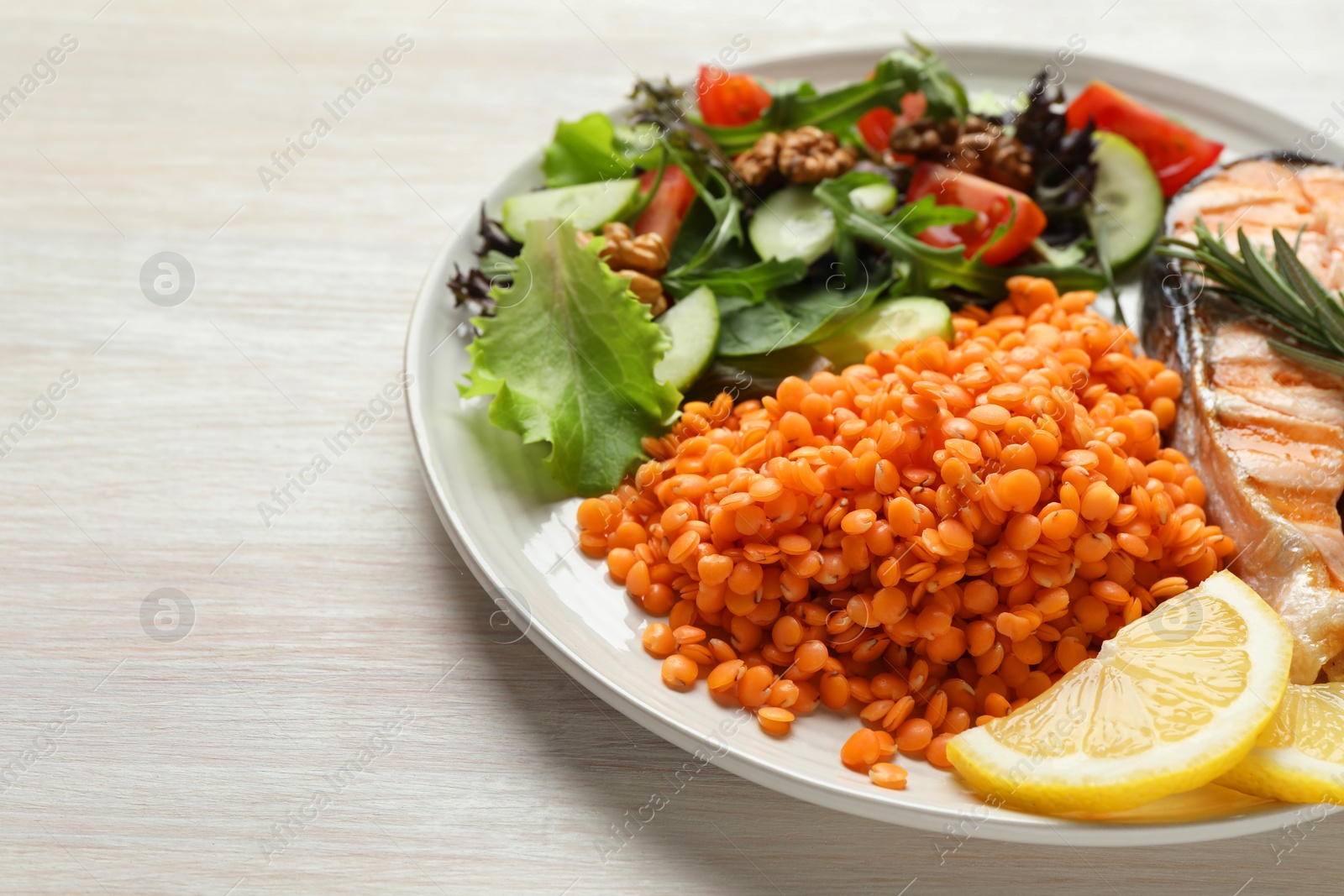 Photo of Plate with healthy food high in vegetable fats on light wooden table, closeup. Space for text