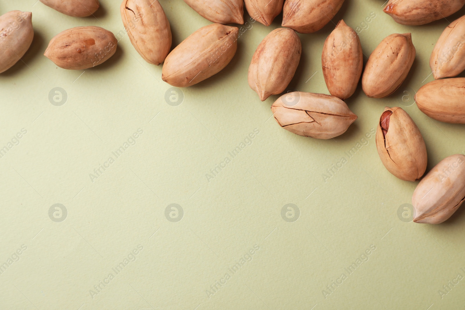 Photo of Composition with ripe pecan nuts on color background, flat lay. Space for text