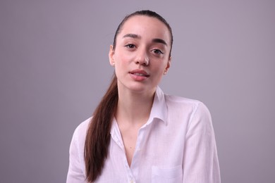 Portrait of beautiful young woman on light grey background