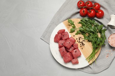 Photo of Raw beef meat and different ingredients for cooking delicious goulash on light grey table, flat lay. Space for text