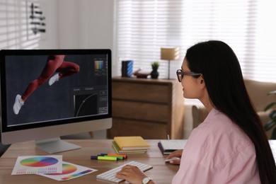 Professional retoucher working on computer in office