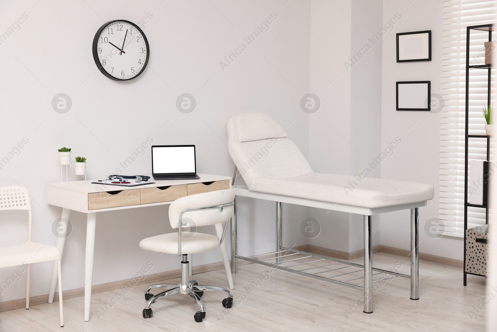 Photo of Modern medical office with doctor's workplace and examination table in clinic