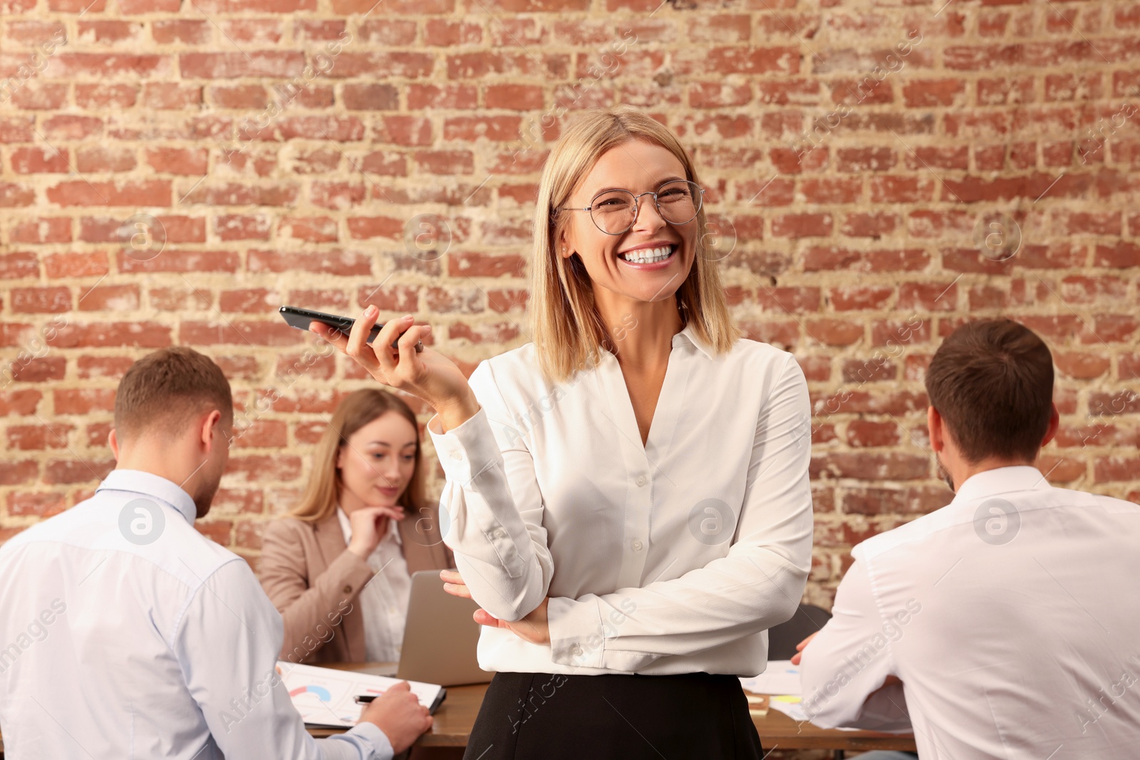 Photo of Businesswoman and her employees in office. Lady boss