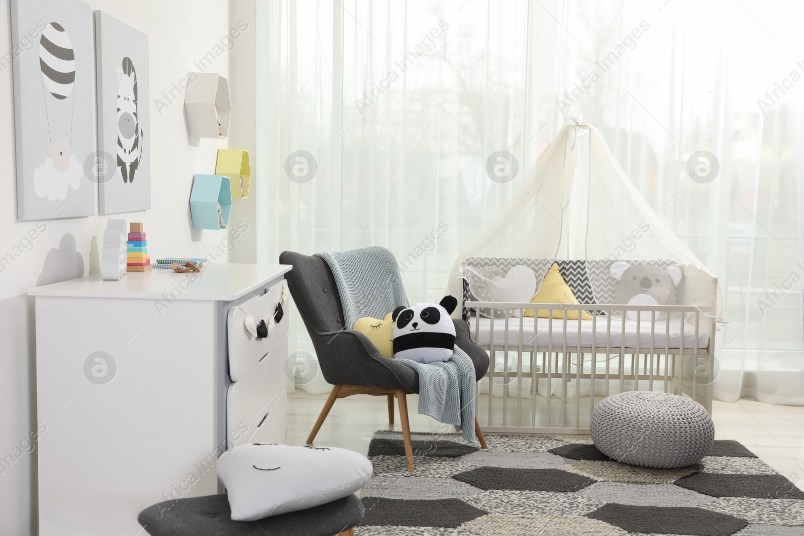 Photo of Cozy baby room with crib and other furniture. Interior design