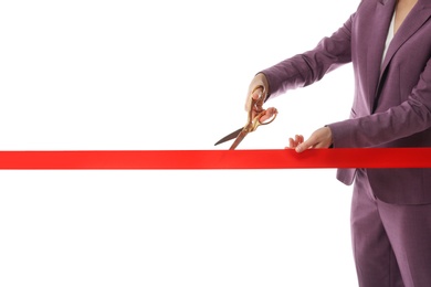 Woman in office suit cutting red ribbon isolated on white, closeup