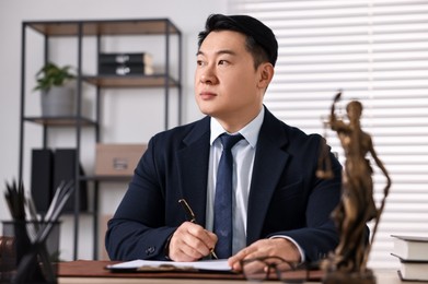 Notary writing notes at wooden table in office