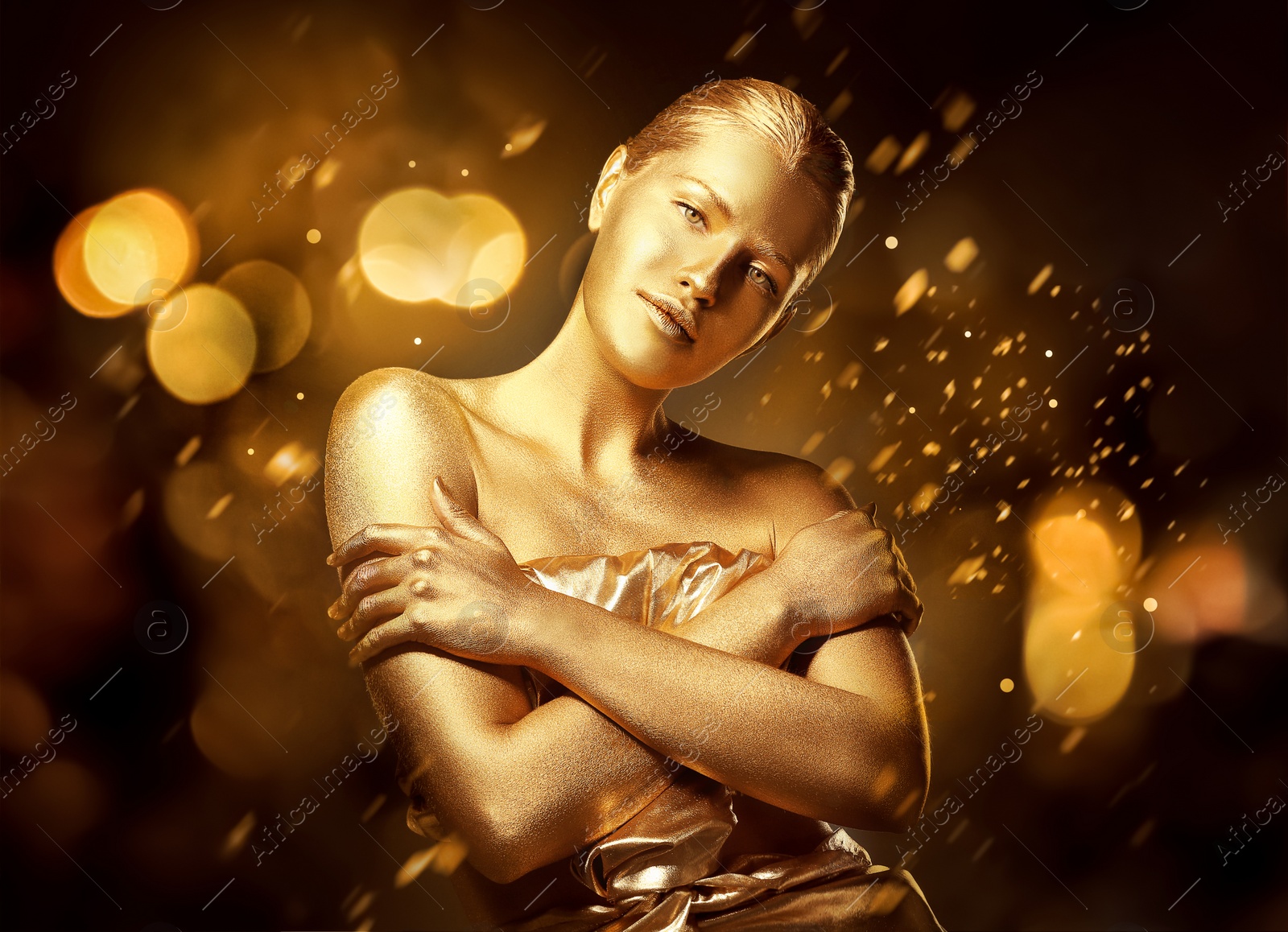 Photo of Portrait of beautiful lady with gold paint on skin against blurred lights