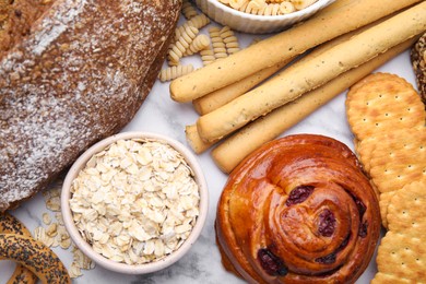 Photo of Different gluten free products on white marble table, flat lay