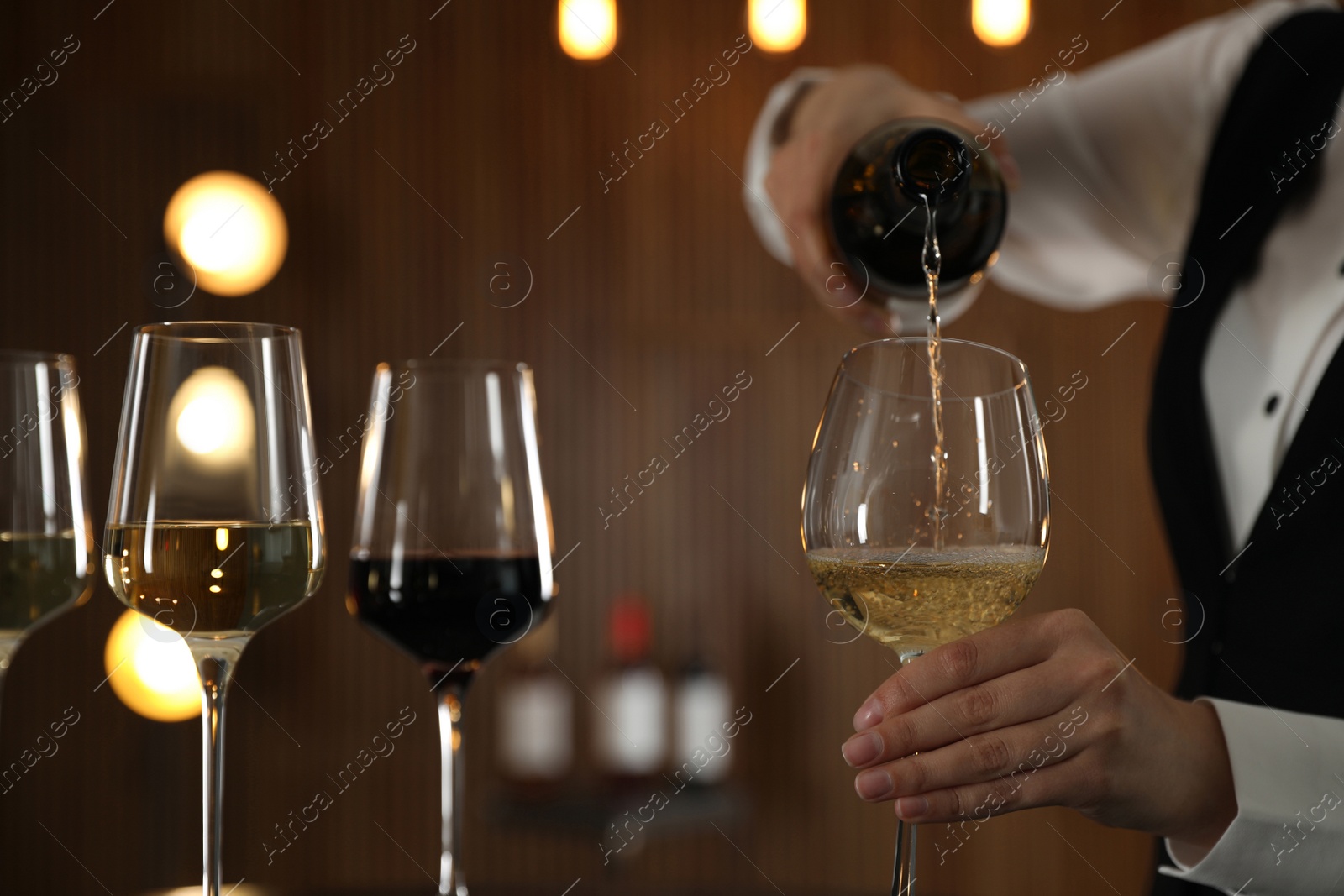 Photo of Waitress pouring wine into glass in restaurant, closeup