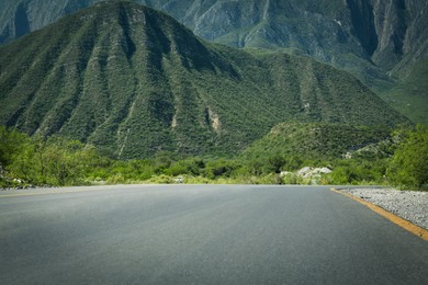 Photo of Picturesque view of big mountains and bushes near road