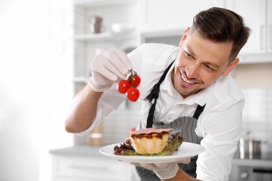 Professional chef presenting delicious dish in kitchen