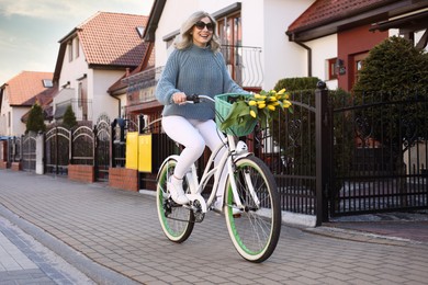 Beautiful woman riding bicycle on city street