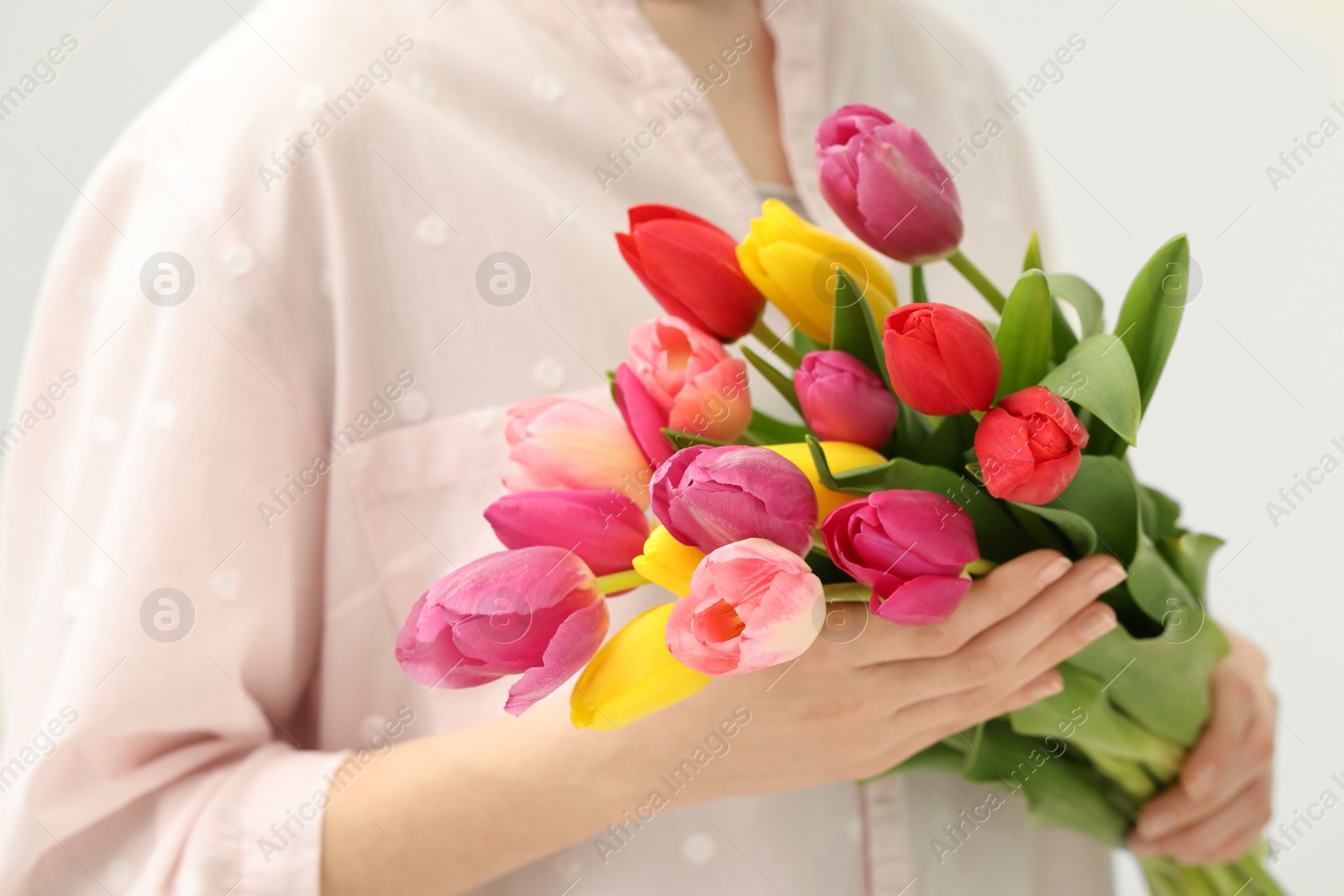 Photo of Woman holding beautiful colorful tulip flowers on white background, closeup