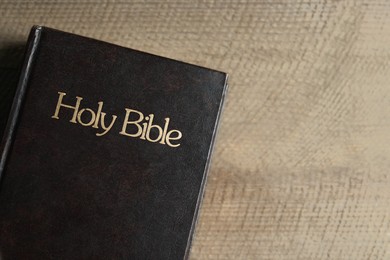 Photo of Holy Bible on wooden table, top view. Space for text