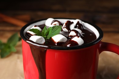 Photo of Mug of delicious hot chocolate with marshmallows and fresh mint, closeup