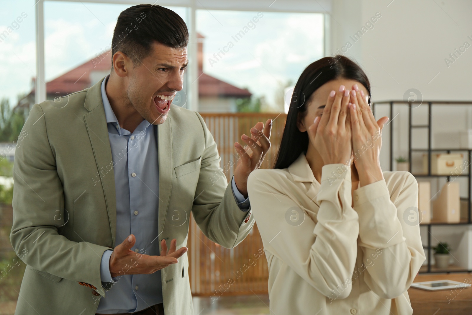 Photo of Boss screaming at employee in office. Toxic work environment