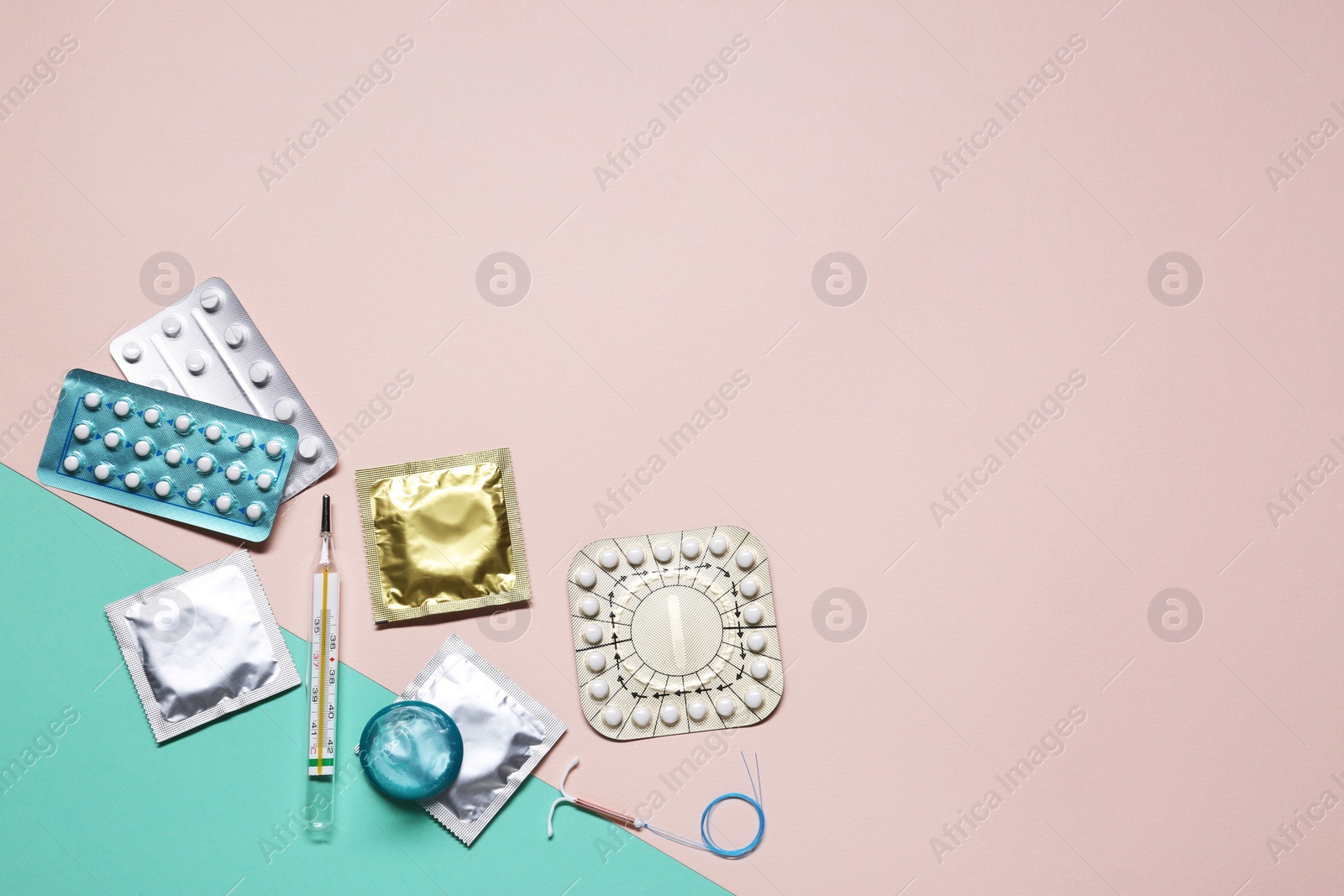 Photo of Contraceptive pills, condoms, intrauterine device and thermometer on color background, flat lay with space for text. Different birth control methods